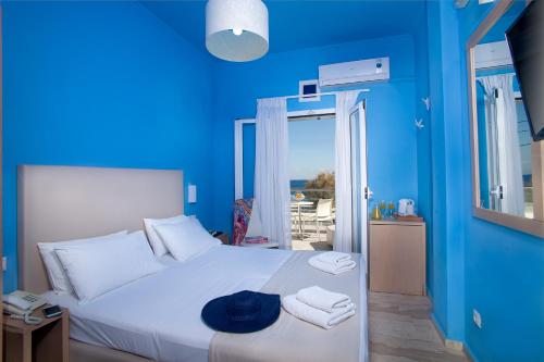 卡马利海神海滩酒店的蓝色卧室,配有带毛巾的床