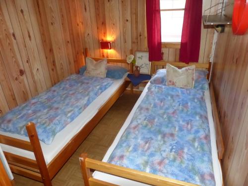 ÅmliVisit Wilderness的木墙客房的两张床