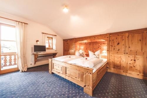 巴特维塞Hotel Garni Gästehaus Brand的一间卧室配有一张大木床和一张书桌