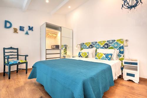 法鲁Blue Barqueta Studio的一间卧室配有一张带蓝色毯子和椅子的床