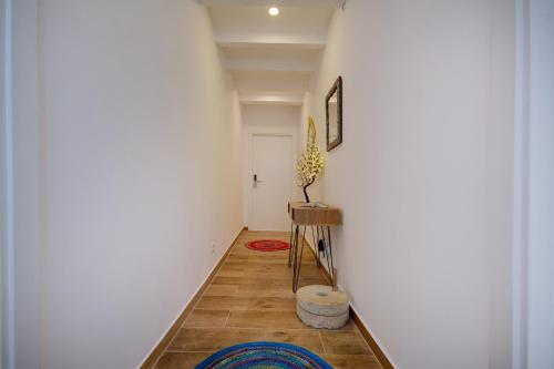 法鲁Yellow Barqueta Studio的走廊上设有白色墙壁和桌子