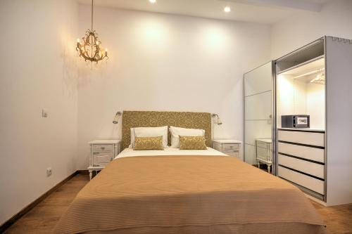 法鲁Yellow Barqueta Studio的一间卧室配有一张大床和一个吊灯。