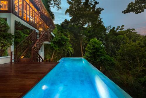 皮皮岛Zeavola Resort的一座树木繁茂的房屋前的游泳池