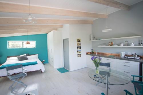 努尔德霍克Selkie - Two Restful Studio Apartments near Noordhoek Beach & Restaurants的一间卧室配有一张床和一张玻璃桌