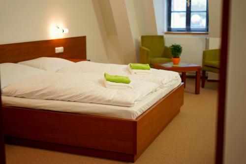 瓦拉什斯凯梅济日奇城堡旅馆的一间卧室配有一张带绿色枕头的床。