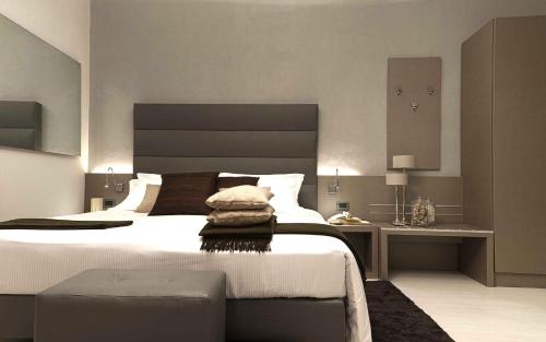 基瓦索Hotel Chivasso的一间卧室配有一张大床和一张书桌