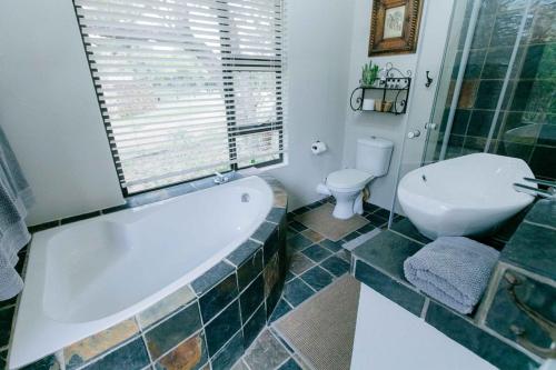 MaguduBelvedere Game Ranch的带浴缸和卫生间的浴室。