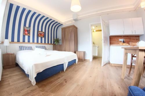 乌斯特卡Mistral Ustka的一间卧室配有一张床和蓝白色条纹墙
