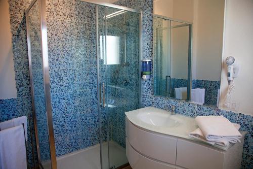 圣特雷莎加卢拉Hotel La Contessa的一间带玻璃淋浴和水槽的浴室