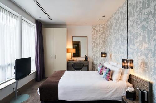 泰晤士河畔金斯顿博斯可酒店的酒店客房,配有床和电视