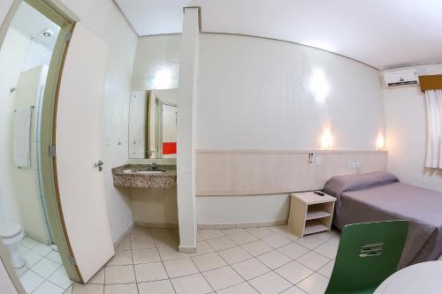 阿雷格里港Hotel Expressinho Aeroporto的小房间设有一张床和一间浴室