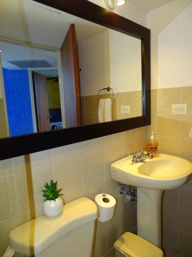 雅科Jaco Beach Condos的一间带水槽、卫生间和镜子的浴室