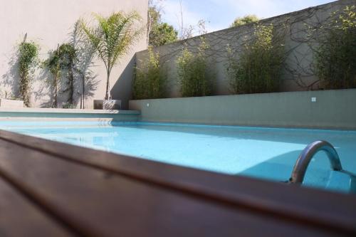 马德普拉塔Departamento Terra IV的一座带水龙头的游泳池,位于大楼旁