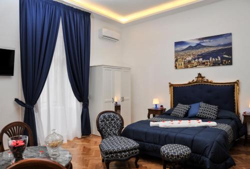 那不勒斯迪帕尔马套房旅馆的一间卧室配有蓝色的床和蓝色窗帘