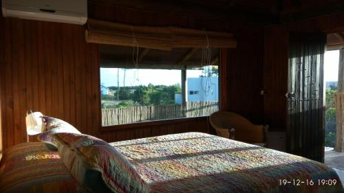 埃斯特角城Hotel El Refugio nudista naturista opcional的一间卧室设有一张床和一个大窗户