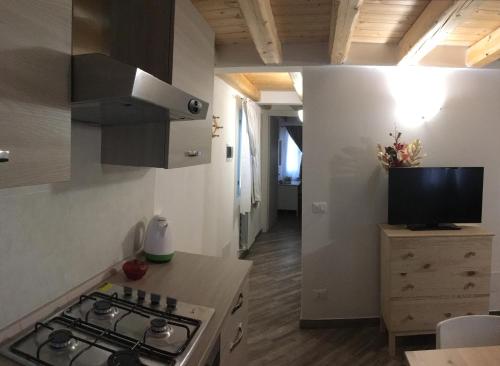 基奥贾South Lagoon Apartments 1的一个带炉灶的厨房和一台台面上的电视
