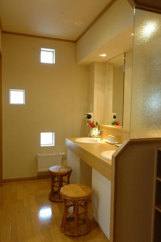 登别登别鲁鲁苏温泉汤原庄日式旅馆的浴室设有水槽、镜子和凳子