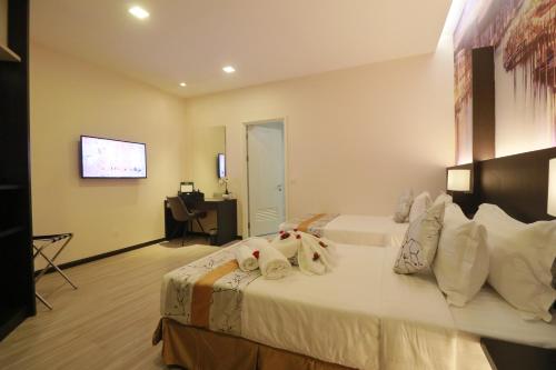 古晋Amamas Boutique Hotel Kuching的酒店客房,配有带毛巾的床