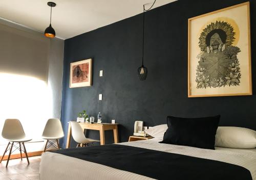 莫雷利亚Hotel Romance Morelia的一间卧室设有黑色墙壁和一张床