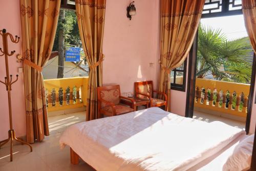 萨帕Thanh Ha Homestay Sapa的卧室配有床、椅子和窗户。