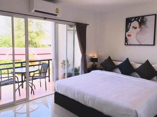 卡马拉海滩Baba Guest House的一间卧室配有一张床,阳台配有桌子