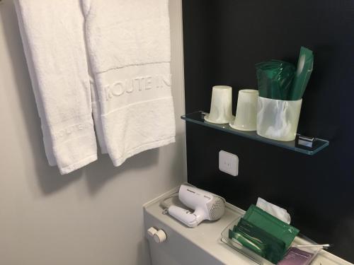 东京东京东阳町站大酒店的浴室配有卫生间、电话和毛巾。