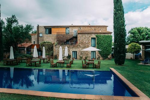 莫奈斯Arcs De Monells - Adults Only的一座带游泳池、桌子和遮阳伞的房子