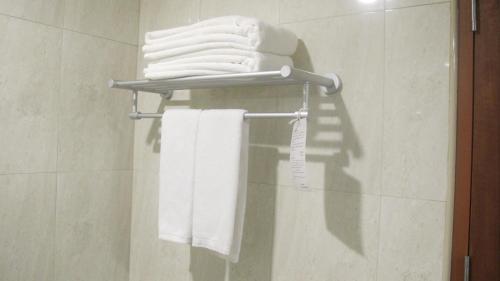 曼谷泰攀酒店 - SHA Plus Certified的浴室毛巾架上的一束毛巾