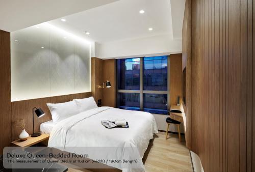 香港康境酒店的卧室设有一张白色大床和一扇窗户。