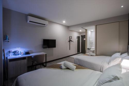 新山列韦瑞吉商务酒店（士姑来）的酒店客房配有两张床和一张书桌