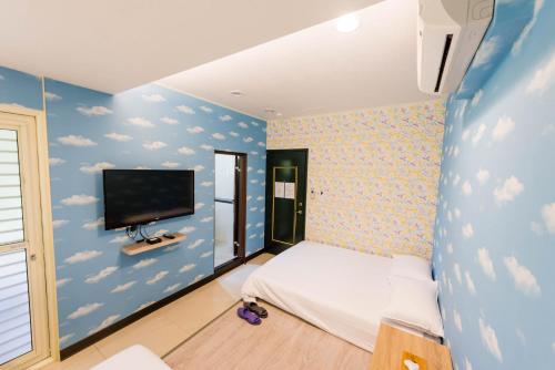 Ruifang瑞芳老街-嫚嫚窝民宿的一间卧室设有蓝色的云墙和电视。