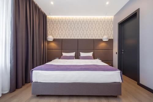 克洛佩夫尼茨基ApartUA Кропивницький的一间卧室配有一张带紫色床单的大床