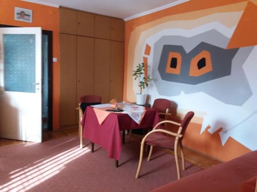 布达凯希布达凯希公寓的一间设有桌子和墙上绘画的用餐室