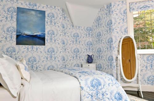 伊斯特布恩Little Friston Lodge的卧室配有蓝色和白色的壁纸和1张床