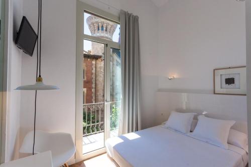 巴塞罗那阿尔戈旅馆的卧室配有白色的床和窗户。