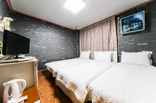 庆州米林汽车旅馆的一间酒店客房,配有一张床和一台电视