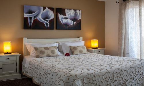 波尔蒂芒雅尔丁做勒沃公寓式酒店的卧室配有带两盏灯的白色床
