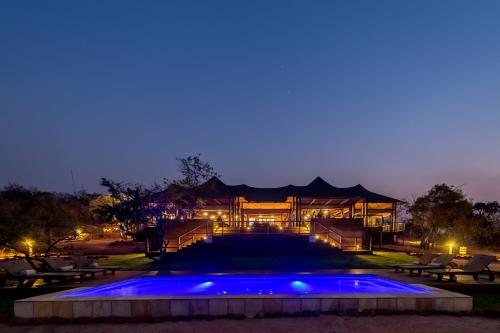 白河Ndhula Luxury Tented Lodge的夜晚带游泳池的房子