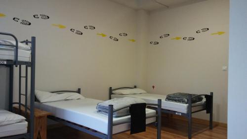萨里亚Alma del Camino - Rooms & Albergue的客房设有两张双层床,墙上挂有汽车