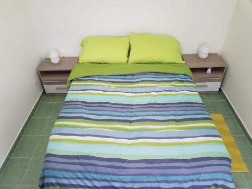拉贡Alifra Apartment的床上铺着彩色条纹毯子