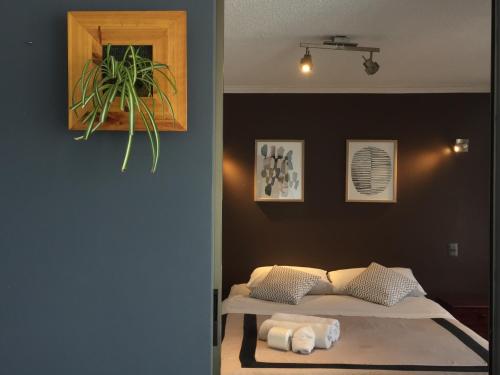 伊基克Espacio Norte Familiar - Cavancha的卧室配有一张床,墙上挂着植物