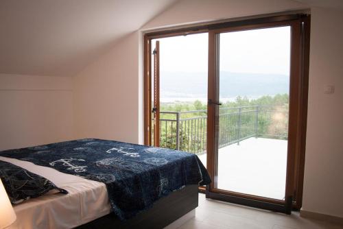 希洛Vila Murvenica的卧室设有通往阳台的大玻璃门