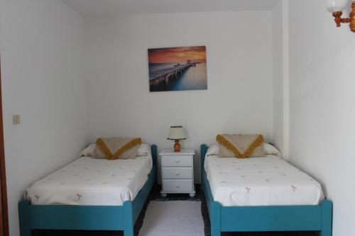 波多·纳奥斯Mi apartamento Mini 2的一间卧室设有两张床和一个挂在墙上的床头柜。