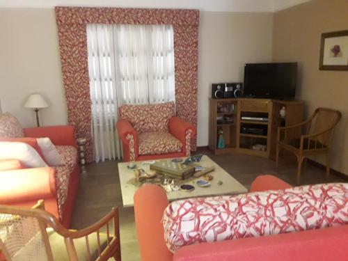 罗萨里奥Hermosa Casa Cerca de Todo的客厅配有沙发、椅子和电视