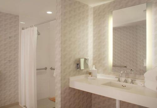 洛杉矶洛杉矶国际机场凯悦酒店的一间带水槽、镜子和淋浴的浴室