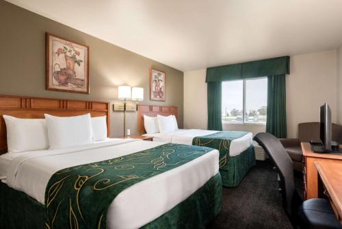Missouri Valley密苏里河谷温德姆旅程住宿酒店的酒店客房设有两张床、一张桌子和一台电视。