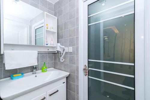 洛阳河南省洛阳市·洛河·路客精品公寓·00137320的一间带水槽和玻璃淋浴间的浴室