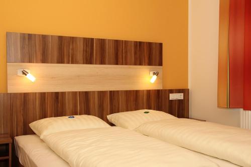 美因河畔克林根贝格Villa Croatia & Restaurant Adria的两张睡床彼此相邻,位于一个房间里