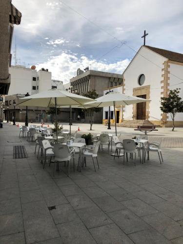 滨海罗克塔斯佩德罗胡安膳食公寓酒店的一个带桌椅和遮阳伞的庭院