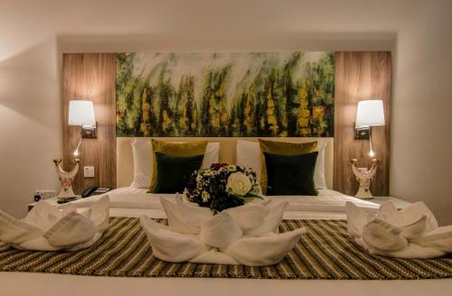 拉斯阿尔卡麦皇家美景酒店的一间卧室配有一张大床和一张大画